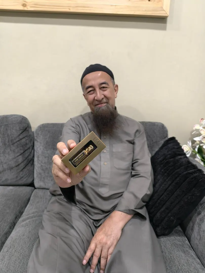 Ustaz memegang perfume UAI Therapy